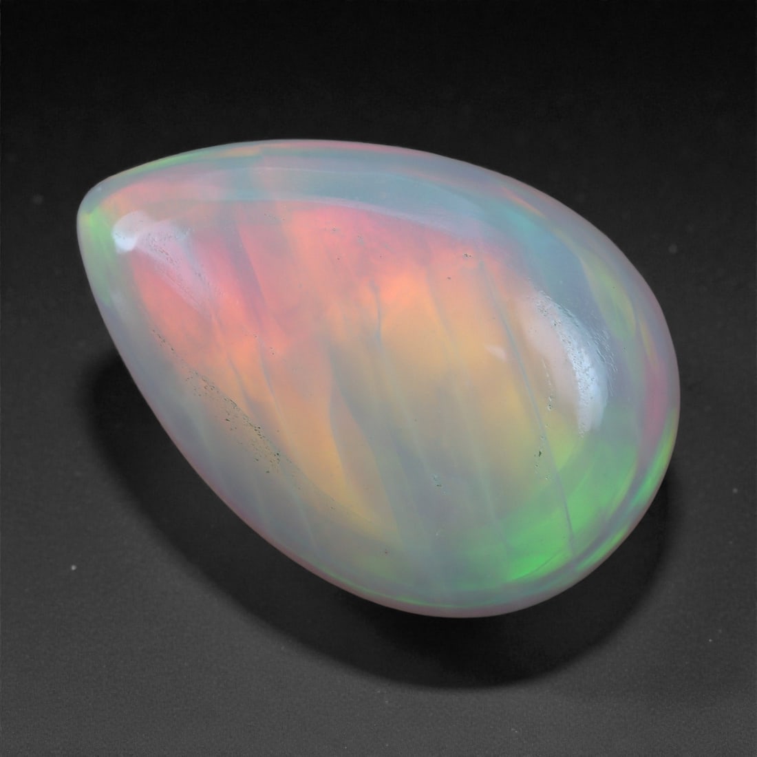 1.97 Carats Play-of-Color Welo Opal - Natural Ethiopian Gem 13x9mm, 90XA: This captivating Welo opal gleams with a luminous cascade of multi neon color that ripple across the stone's surface with every movement. The play-of-color is vivid and well-distributed, presenting a