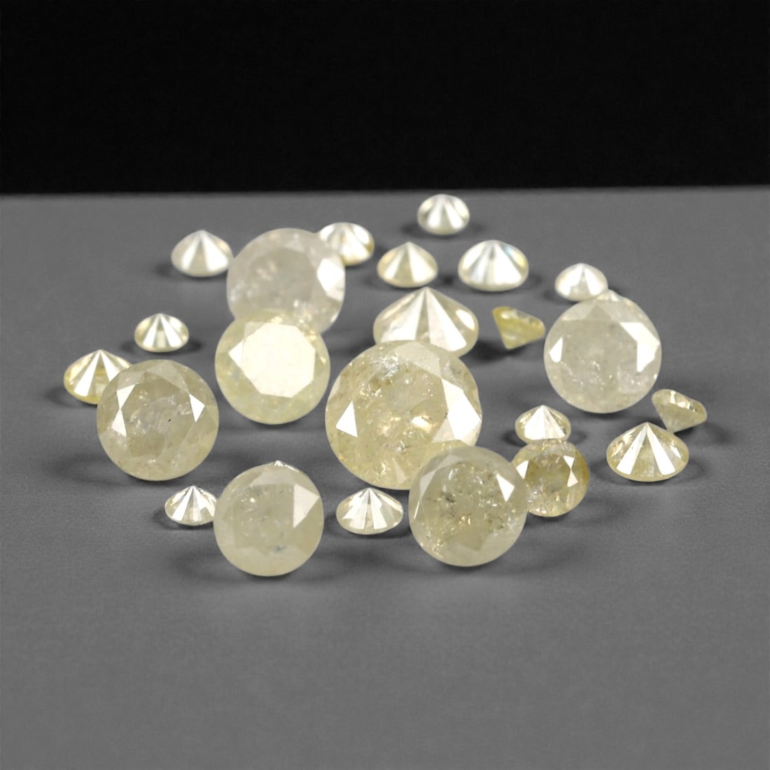 1.01 Carats Fancy Yellow Diamond Parcel - Natural African Stones, 46A: This exquisite parcel of round fancy diamonds radiates with a warm, honeyed glow, ranging from soft lemon and buttercup hues to deeper golden amber tones. Each stone is precision-cut to maximize light