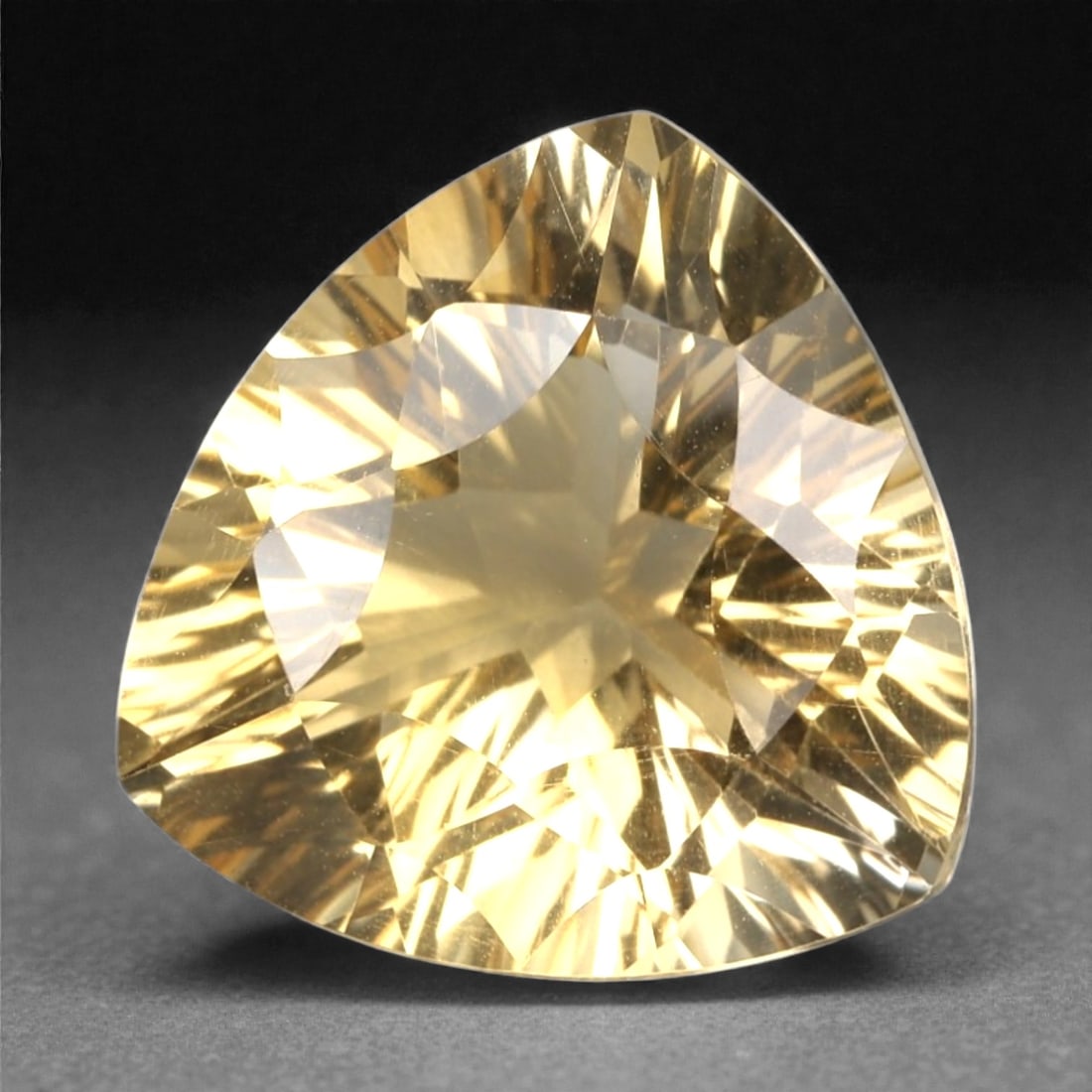 5.66 Carats Golden Yellow Citrine - Natural Brazilian Stone, 379A: This exceptional trillion-cut citrine gemstone captivates with a rich, honeyed golden-yellow hue, reminiscent of sunlit amber and liquid gold. The precision faceting maximizes light dispersion, creati