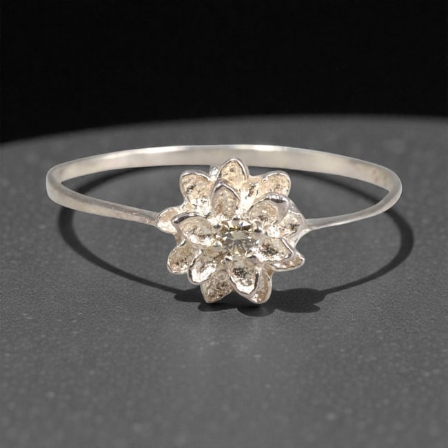 Sterling Silver (925) Ring with Diamond Floral Setting - Size 7.5 US, 136A: This elegant ring is crafted from polished sterling silver, featuring a slender, flat band that culminates in a detailed floral setting. The centerpiece is a small, round-cut diamond, nestled at the h