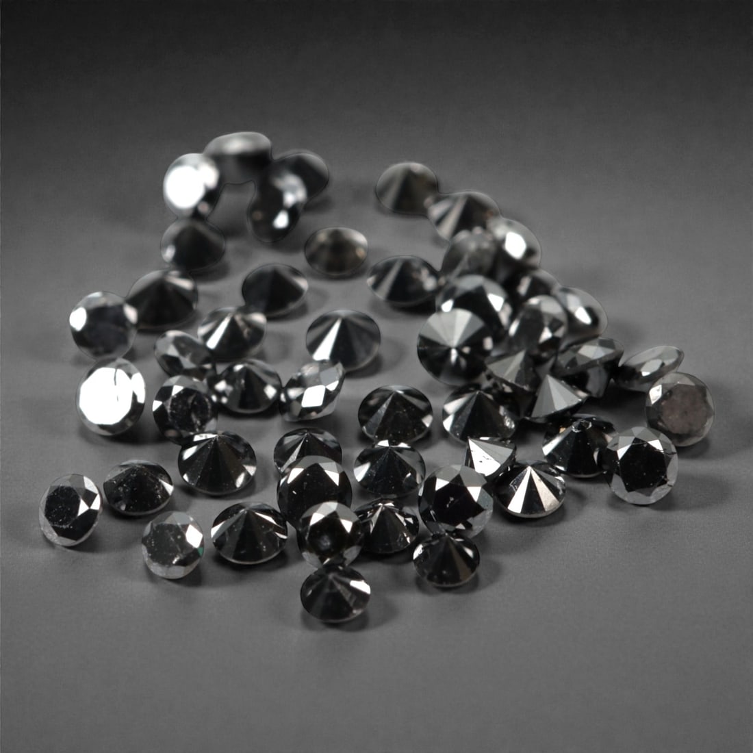 50 Pieces Black Diamond Parcel - Round Brilliant Cut, 1.7mm, 176A: This versatile parcel of 50 loose black diamond gems captivates with a deep, opaque black hue that evokes the intensity of polished obsidian and the mystery of a midnight sky. Each stone is cut in a w