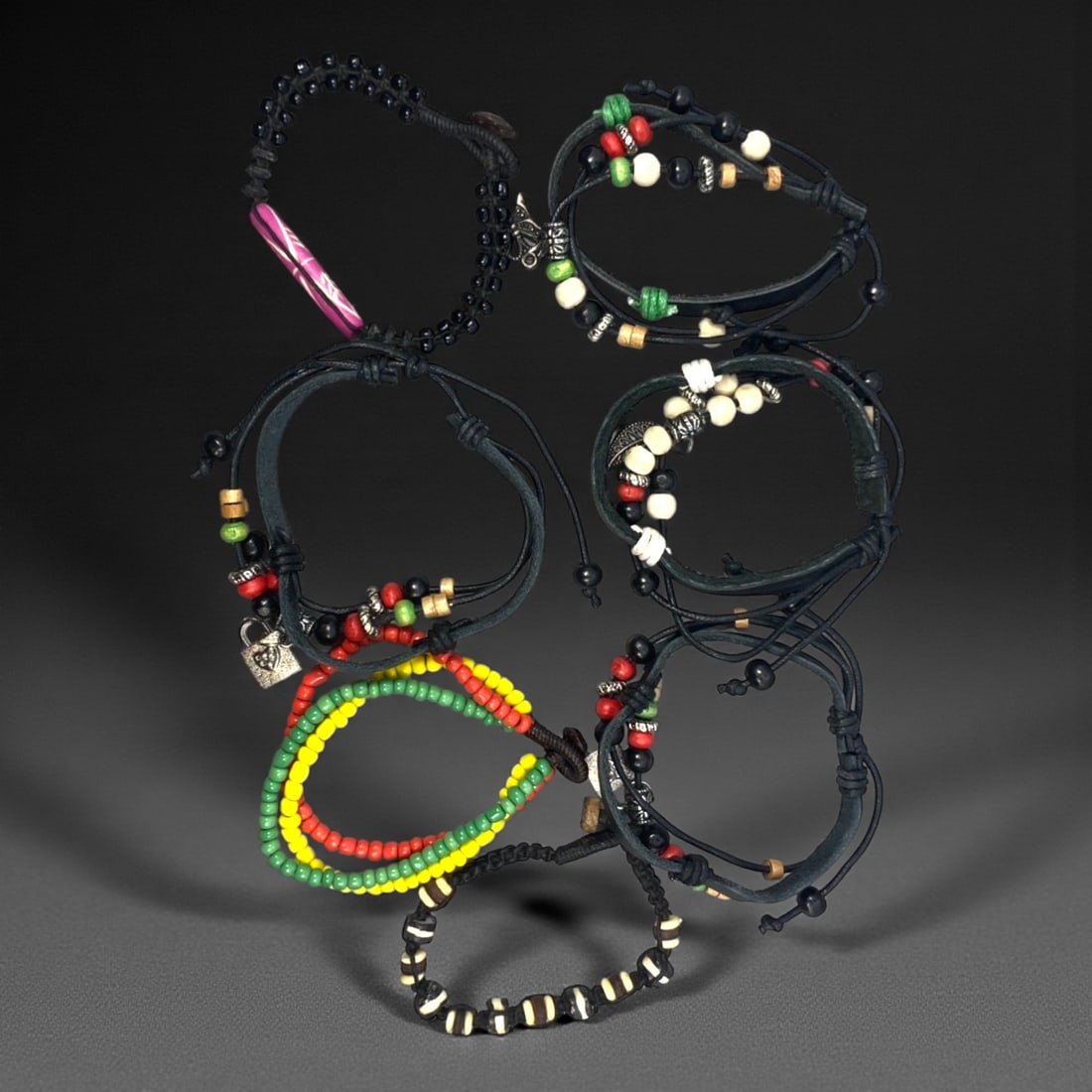A Group of Seven Leather and Beaded Bracelets, Late 20th-Early 21st Century, 37ZG: The group comprises seven bracelets constructed from leather cords combined with assorted beads and minor metal fittings. The designs vary and include wrapped and layered leather elements, adjustable