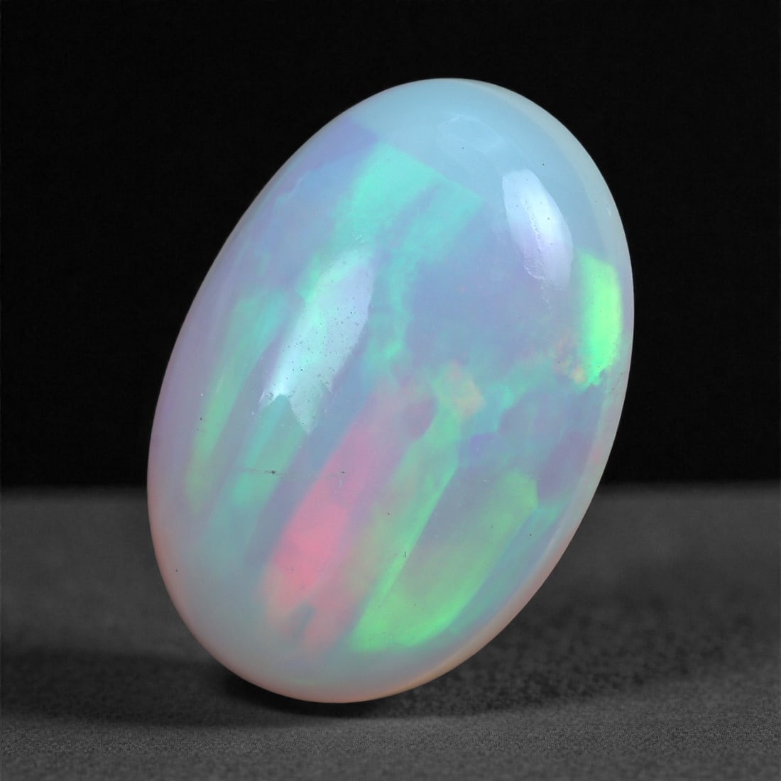 2.47 Carats Play-of-Color Welo Opal - Natural Ethiopian Gem 12x9mm, 22XA: This captivating Welo opal gleams with a luminous cascade of multi neon color that ripple across the stone's surface with every movement. The play-of-color is vivid and well-distributed, presenting a 