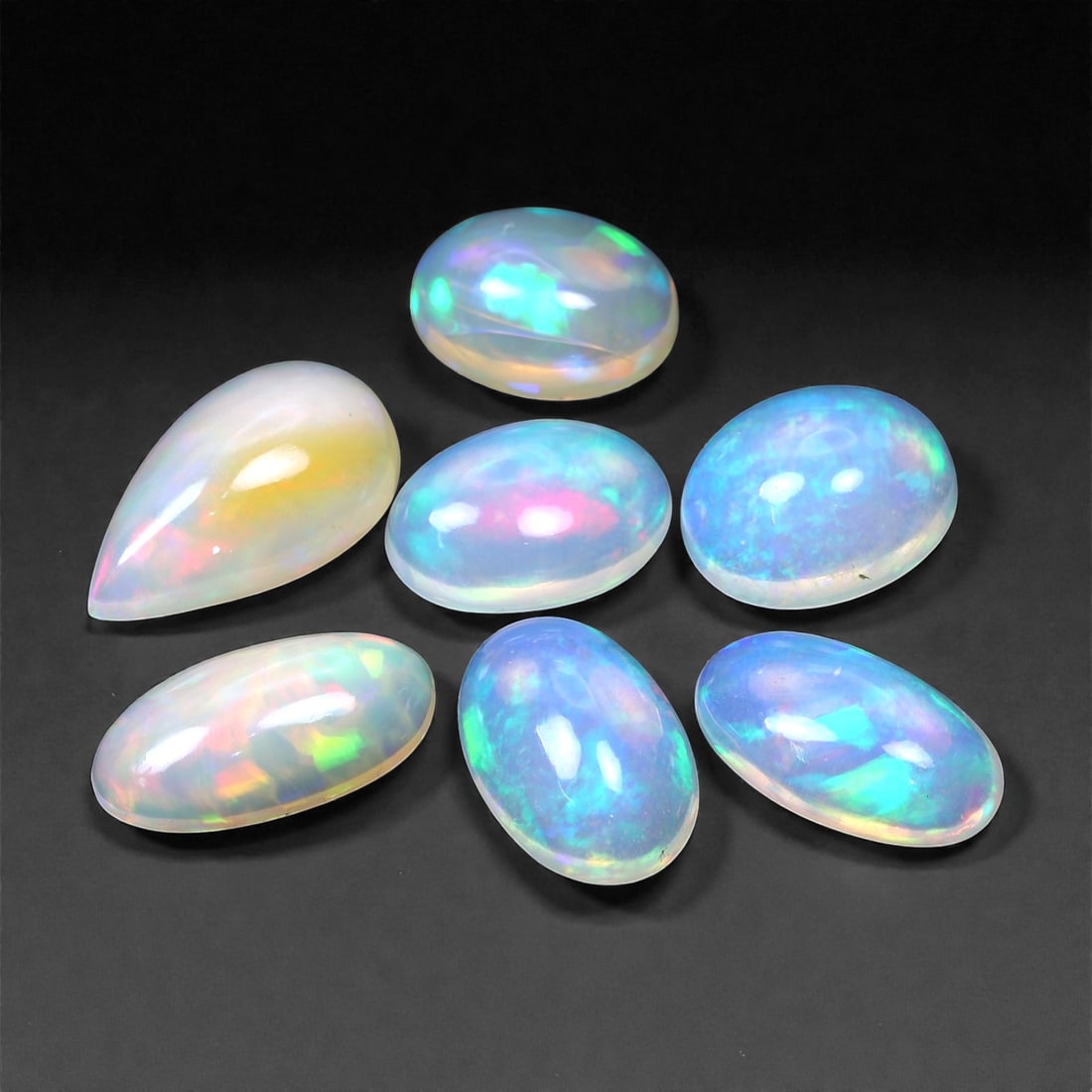15.47 Carats Pastel Fire Opal Parcel - Natural Ethiopian Stones, 10-14mm, 59XH: This luminous parcel of cabochon-cut opals radiates a delicate pastel glow with bursts of vivid fire. Shimmering hues of aqua blue, fuchsia, lemon yellow, and mint green dance beneath the surface, fra
