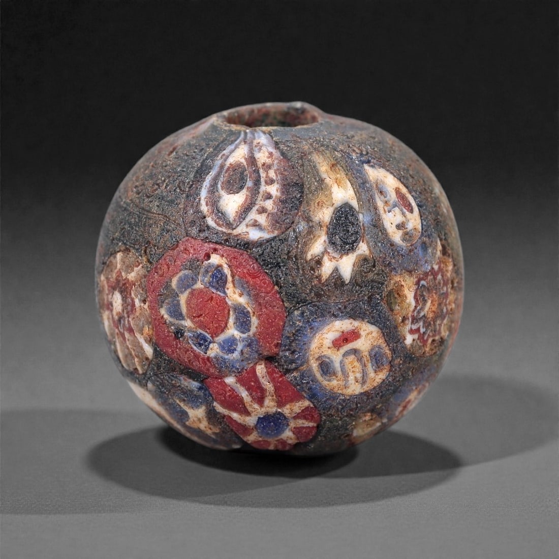 Antique Glass Bead - Venetian Scramble Cane Sphere, 54Z: This spherical glass bead is formed from a dense composite of scrambled millefiori and patterned cane fragments fused into a dark glass matrix, a technique commonly referred to as Venetian "scramble"