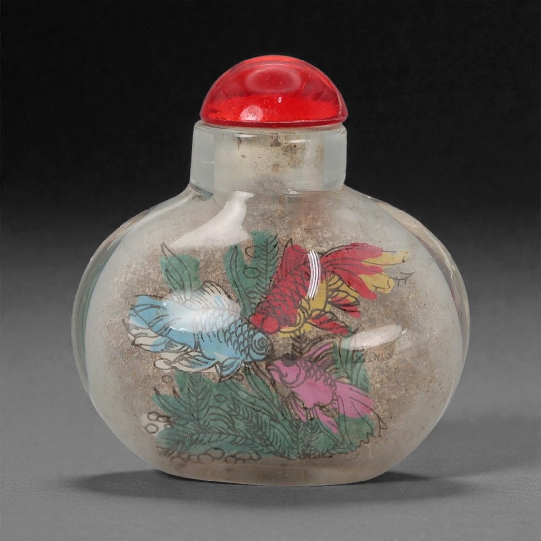 A Chinese Glass Snuff Bottle with Painted Decoration, 20th Century, 57FD: Formed from clear glass with a rounded flattened body and a short cylindrical neck, fitted with a domed red stopper. The interior is hand-painted with polychrome decoration depicting birds and floweri