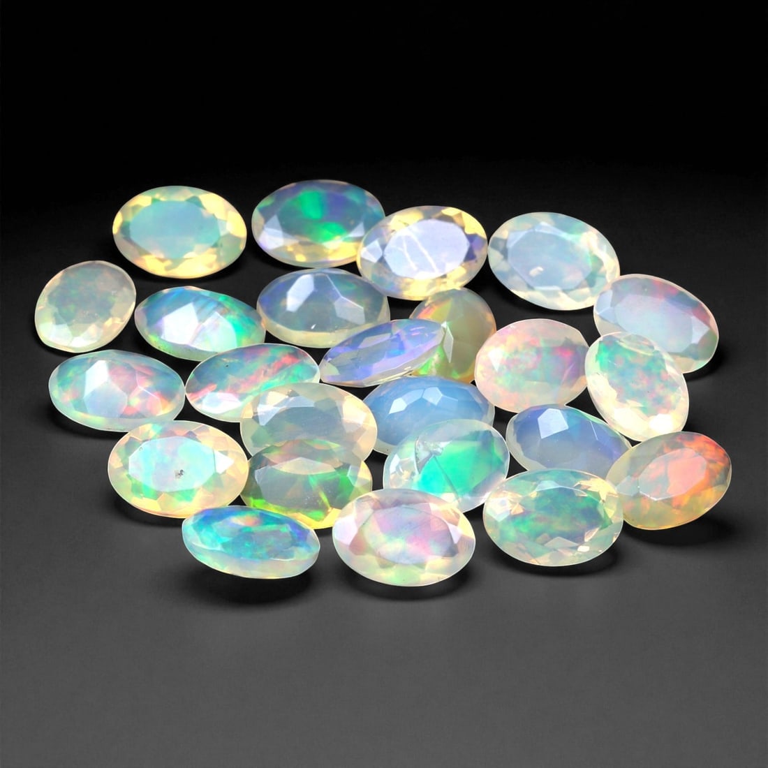 6.85 Carats Oval Cabochon Opal Parcel - Natural Welo Ethiopian Stones, 99XC: This mesmerizing parcel features 6x4 mm oval-cut opals, each glowing with exceptional play-of-color across a luminous, translucent body. Flashes of electric green, oceanic blue, and golden orange shif