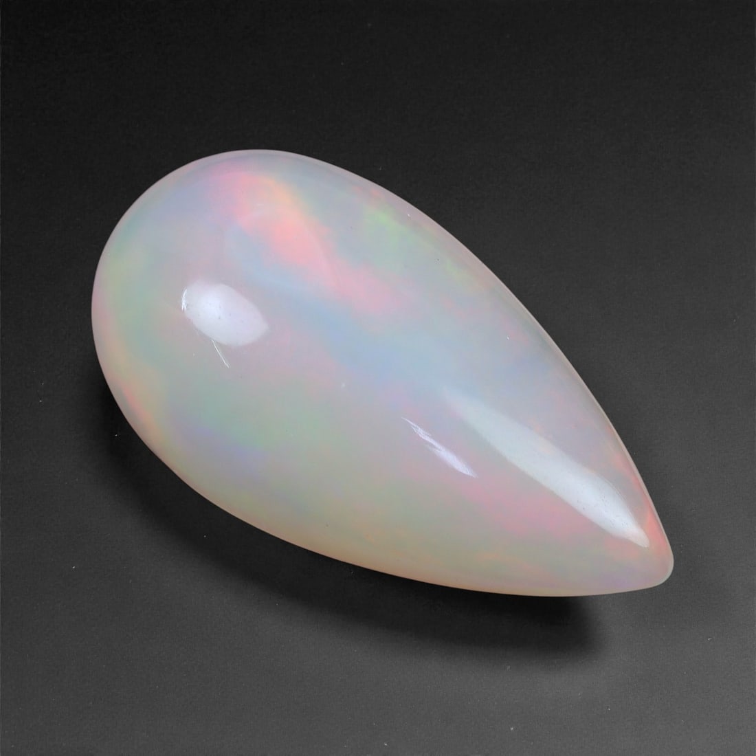 3.45 Carats Roseveil Welo Opal - Natural Ethiopian Gemstone 11.9x9.8x5.3mm, 51XH: This elegant Welo opal displays a gentle gradient of blush pink, sky blue, and apricot orange that flows beneath its smooth, elongated surface. The pastel color play has a soft, veil-like effect-ether
