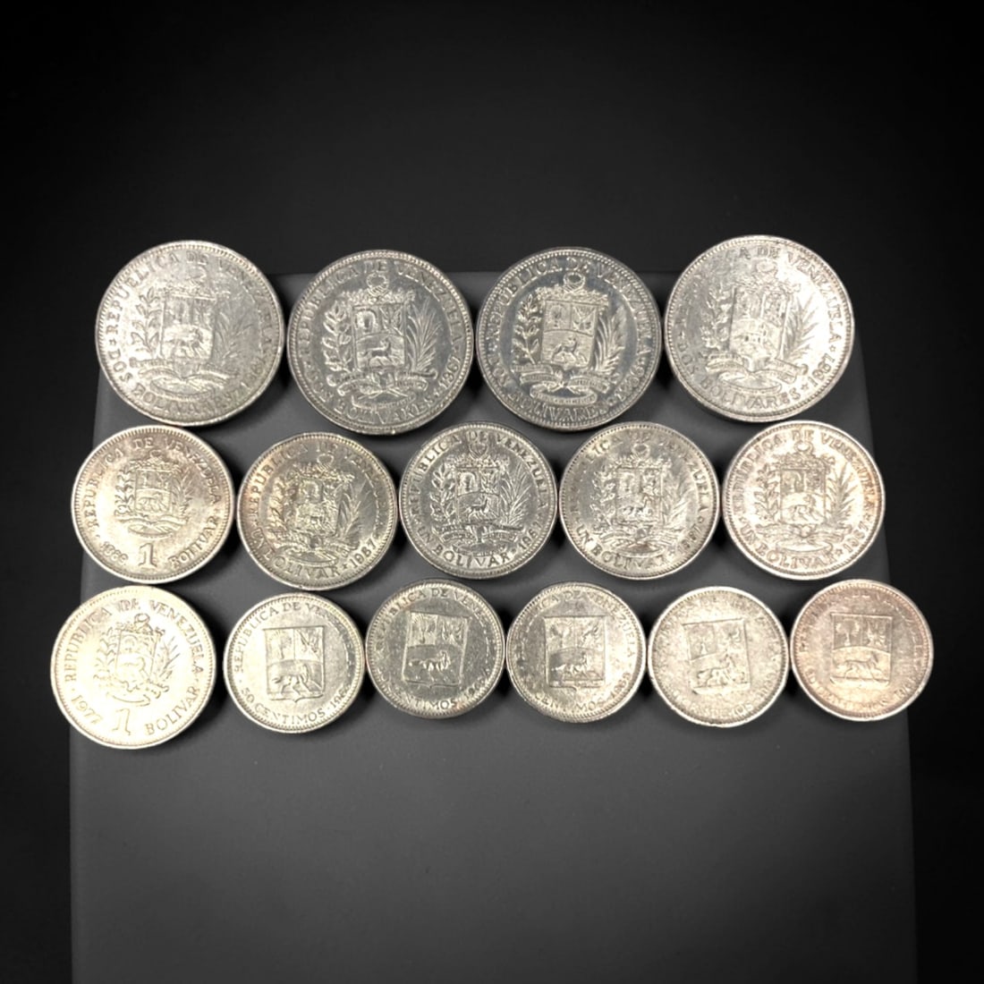 VENEZUELA: Bolivarian Legacy - 15-Piece Coins Set, 1965-1990, 20-27mm, 53ZJ: This 15-Piece Coins Set of Venezuelan coins, minted between 1965 and 1990, encapsulates the nation's enduring Bolivarian legacy and evolving economic identity. Ranging from 20 to 27mm in diameter, the