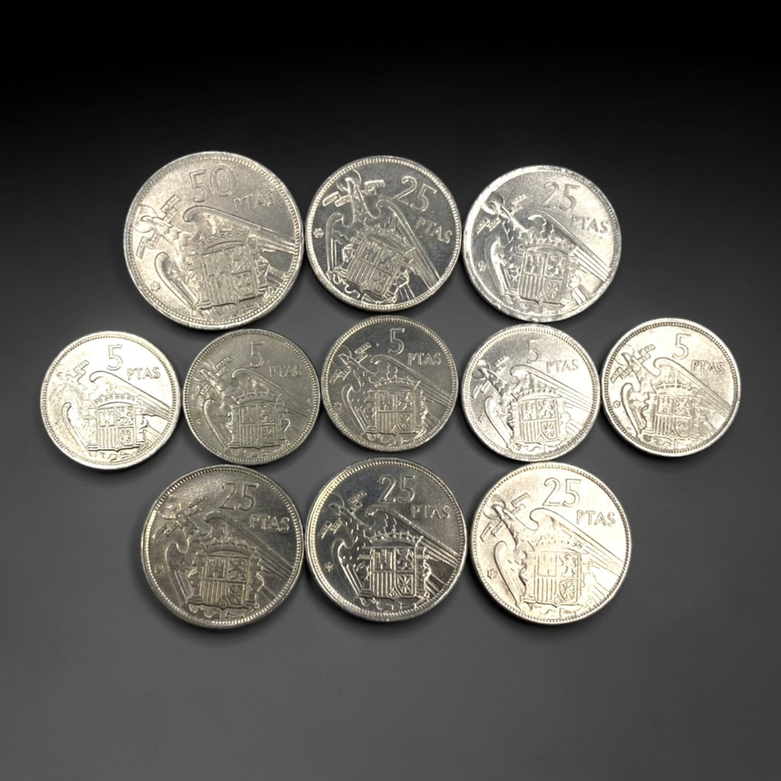 SPAIN: Franco Era Nationalist Coinage - 11-Piece Coins Set, 1953-1957, 23-30mm, 17ZJ: This 11-Piece Coins Set of Spanish Pesetas coins, minted between 1953 and 1957, encapsulates the nationalist identity of the Franco regime. Ranging from 23 to 30mm in diameter, the set features denomi