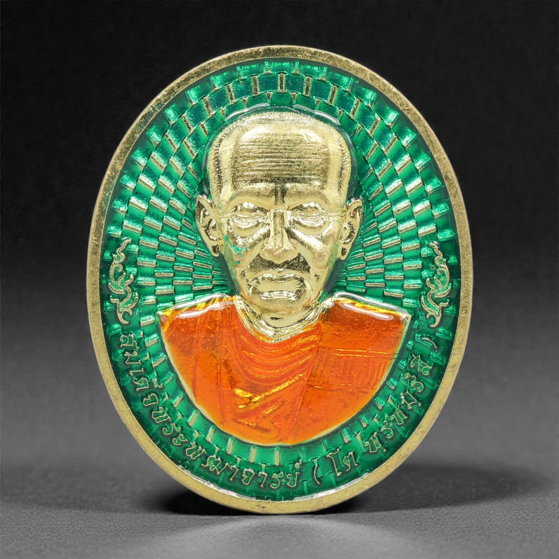 A Thai Gilt-Metal and Enamel Monk Portrait Medallion, 21st Century, 85FP: Cast from metal with a gilt surface finish, the medallion is oval and double-sided with a raised gilt-metal border. The obverse features a high-relief gilt bust portrait of a Buddhist monk, set agains