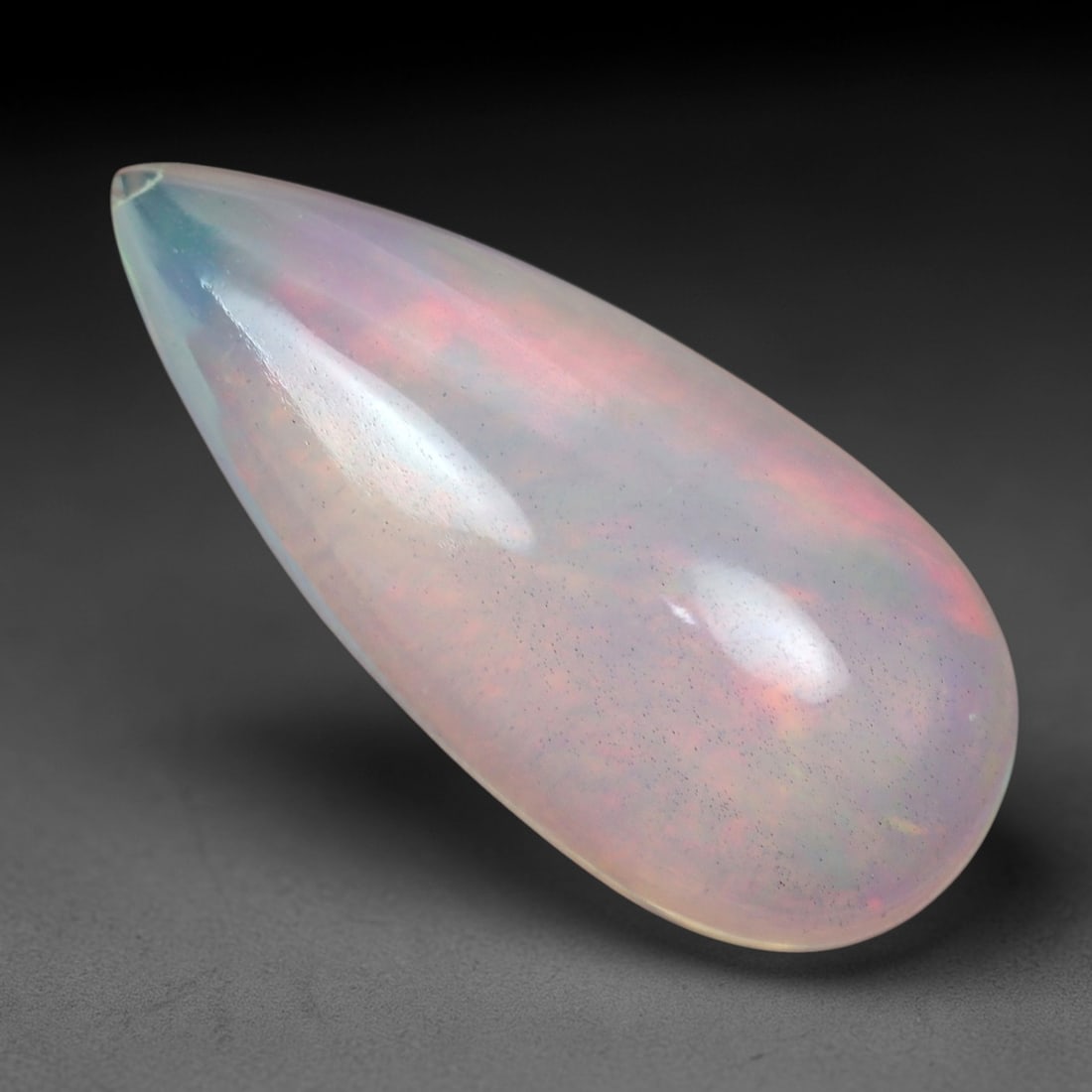 3.49 Carats Multicolor Iridescent Welo Opal Cabochon - Natural Ethiopian 18x8mm, 73XM: This luminous Welo opal cabochon radiates with a soft, milky translucence, its pale, creamy base alive with a delicate play of color. Subtle flashes of peachy-pink, cool lavender, and faint green shif