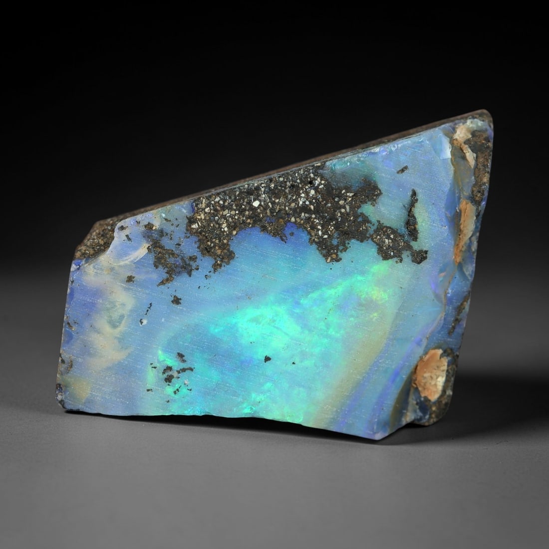 13.60 Carats Iridescent Blue-Green Winton Opal Rough - Natural Australian Specimen 18X13mm, 86XM: This exceptional rough opal from Winton, Australia, displays a breathtaking play of color, with vivid flashes of electric green and celestial blue swirling through a milky, translucent base. The natur