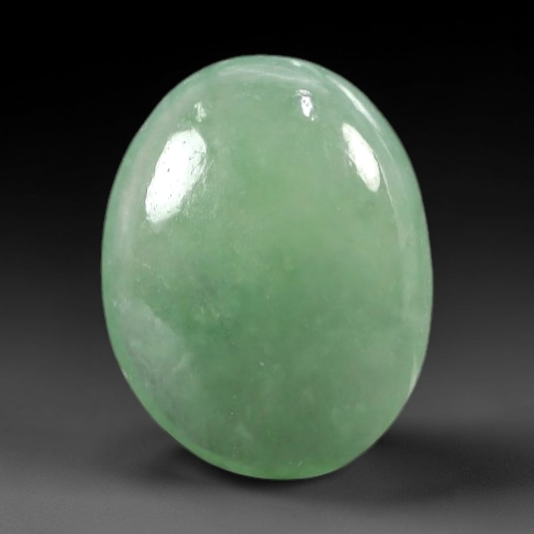 2.12 Carats Soft Mint Green Burmese Jadeite Jade Cabochon - Natural Loose Gemstone, 57AC: This oval Burmese jadeite jade cabochon exhibits a soft, uniform mint green hue, with a milky translucency that diffuses light evenly across its smooth, polished surface. The stone's even color distri