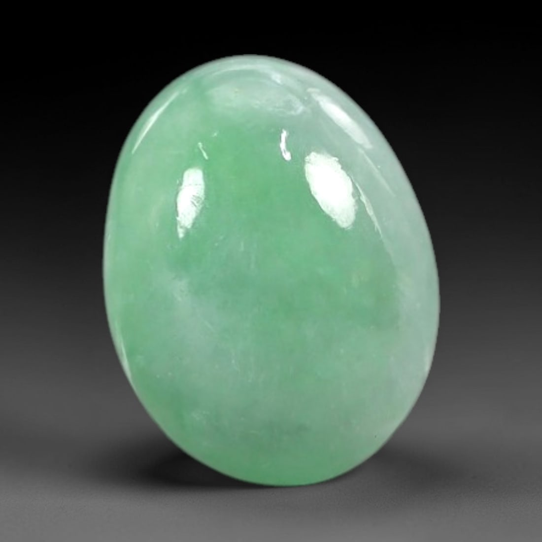 2.61 Carats Vivid Spring Green Burmese Jadeite Jade Cabochon - Natural Loose Gemstone, 53AC: This oval Burmese jadeite jade cabochon exhibits a vivid spring green hue, with a milky translucency that diffuses light evenly across its smooth, polished surface. The stone's consistent color distri