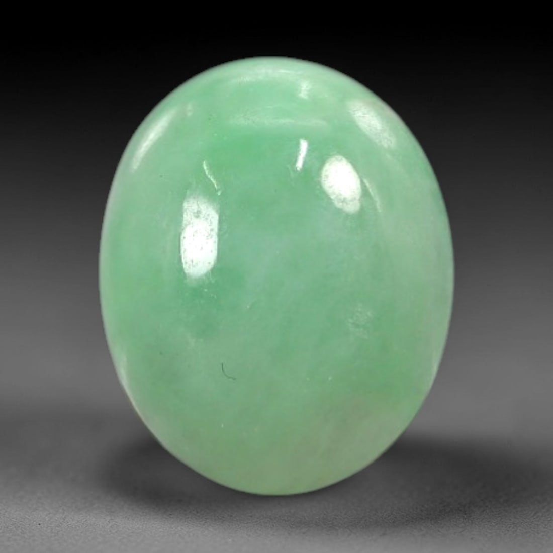3.02 Carats Soft Mint Green Burmese Jadeite Jade Cabochon - Natural Loose Gemstone, 54AC: This oval Burmese jadeite jade cabochon exhibits a soft, uniform mint green hue, with a milky translucency that diffuses light evenly across its smooth, polished surface. The stone's even color distri