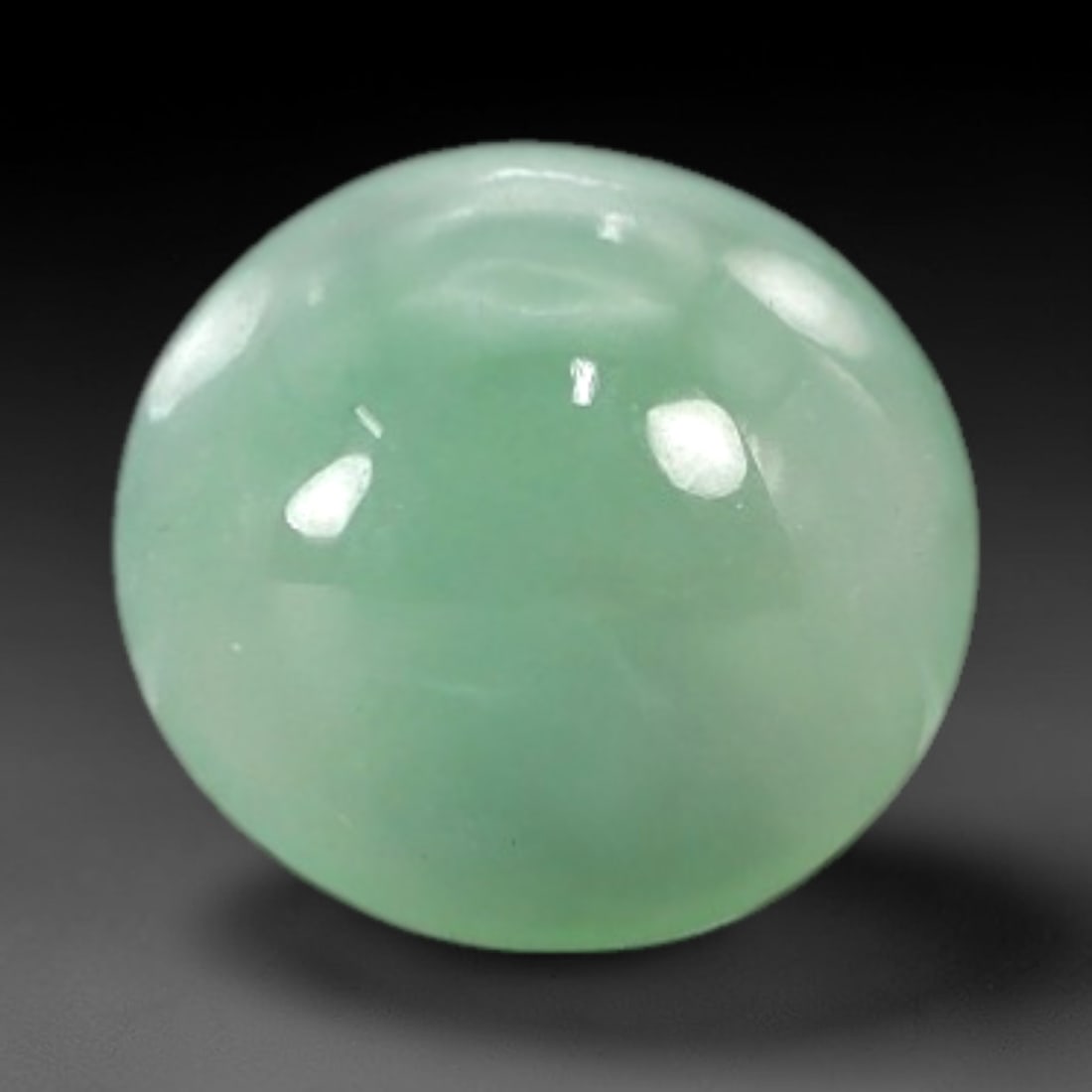 1.73 Carats Pale Mint Green Burmese Jadeite Jade Cabochon - Natural Loose Gemstone, 26AC: This round Burmese jadeite jade cabochon exhibits a soft, pale mint green hue, with a milky translucency that diffuses light evenly across its smooth, polished surface. The stone's even color distribu