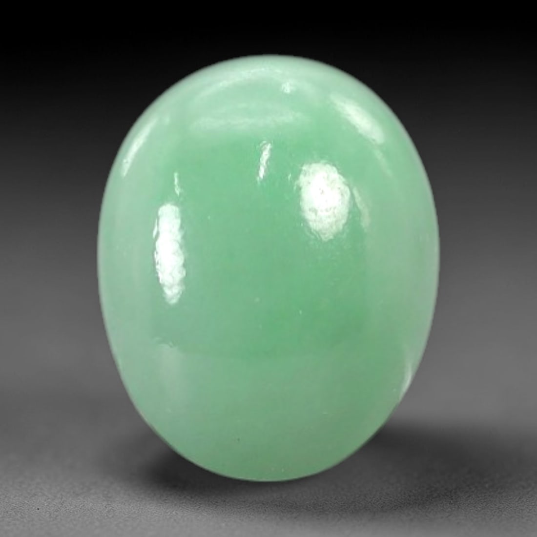 2.36 Carats Vivid Mint Green Burmese Jadeite Jade Cabochon - Natural Loose Gemstone, 40AC: This oval Burmese jadeite jade cabochon features a vivid, uniform mint green hue, with a milky translucency that diffuses light evenly across its smooth, polished surface. The stone's consistent color