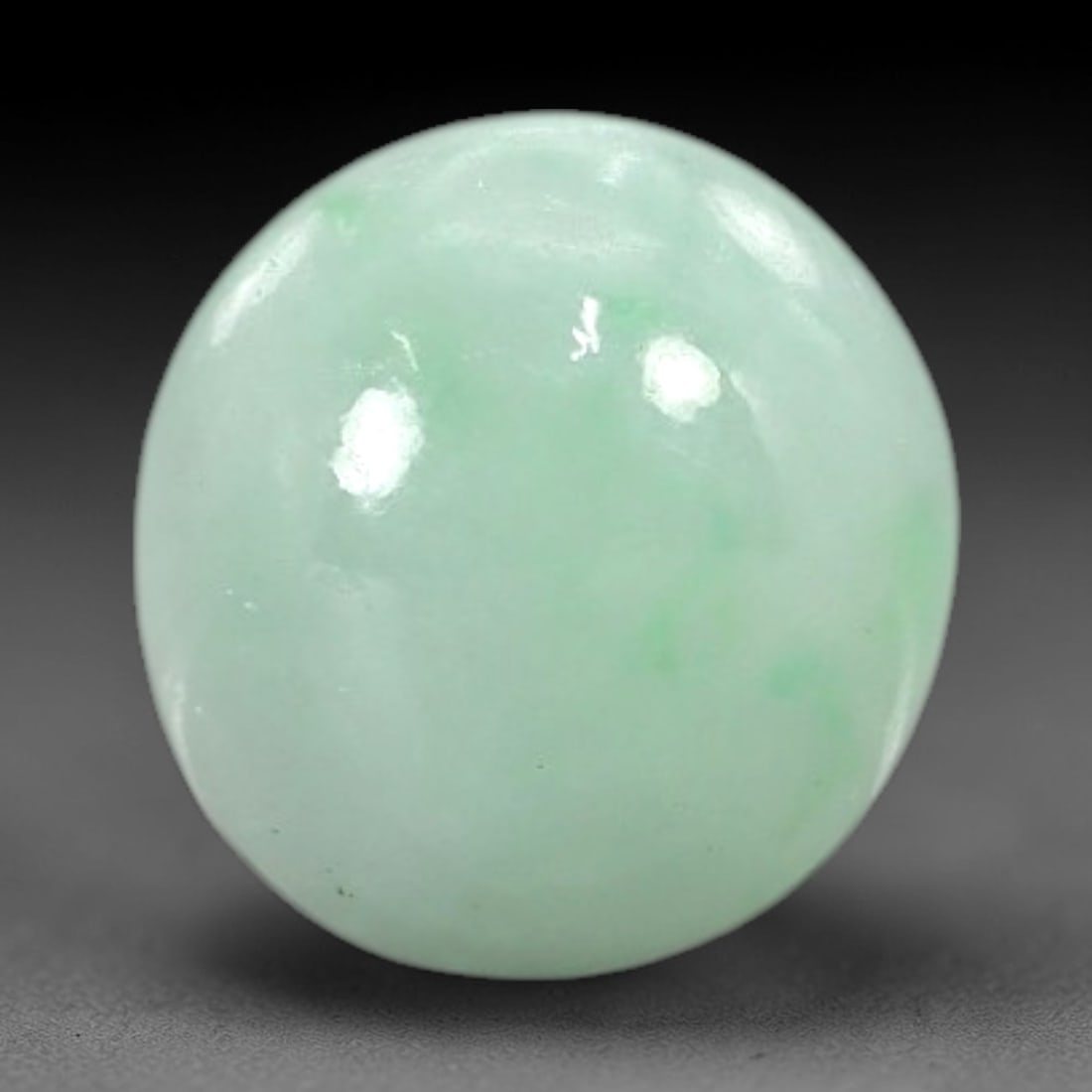 3.00 Carats Pale Apple Green Burmese Jadeite Jade Cabochon - Natural Loose Gemstone, 39AC: This round Burmese jadeite jade cabochon exhibits a soft pale apple green hue, with delicate, scattered patches of richer green that add subtle depth to its milky translucency. The smooth, polished su