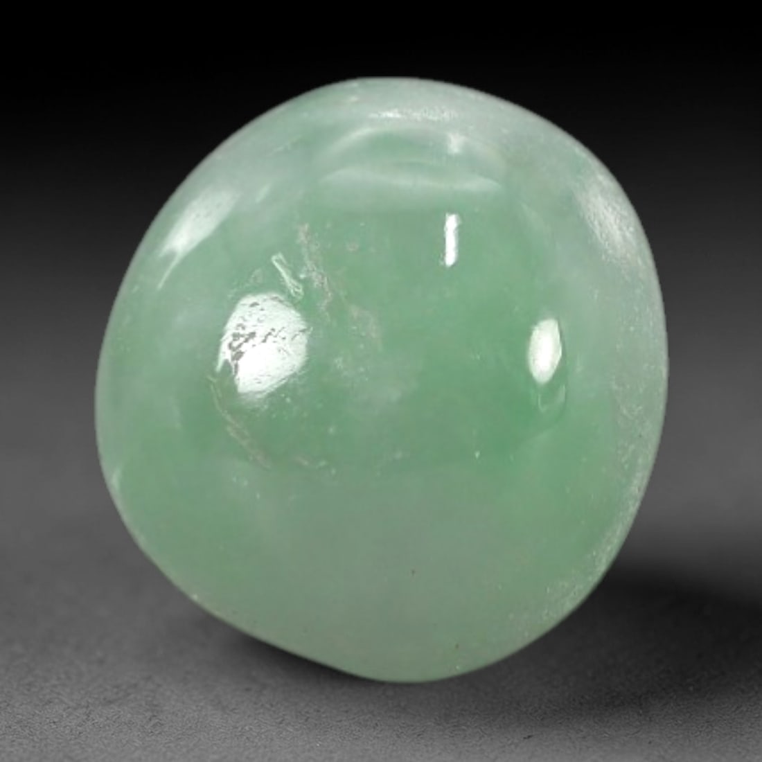 2.61 Carats Apple Green Burmese Jadeite Jade Cabochon - Natural Loose Gemstone, 33XN: This singular Burmese jadeite jade cabochon presents a luminous apple green hue, soft and luminous with a translucent quality that allows light to filter gently through its smooth, domed surface. The