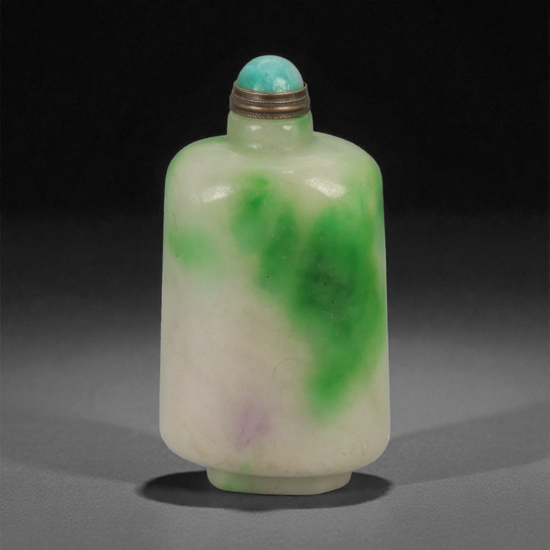 A Chinese Jadeite Jade Snuff Bottle, 20th Century, 57YB: Carved from pale jadeite with areas of translucent milky white ground interspersed with vivid green inclusions and minor natural mottling, the bottle is of flattened ovoid form with gently rounded sho
