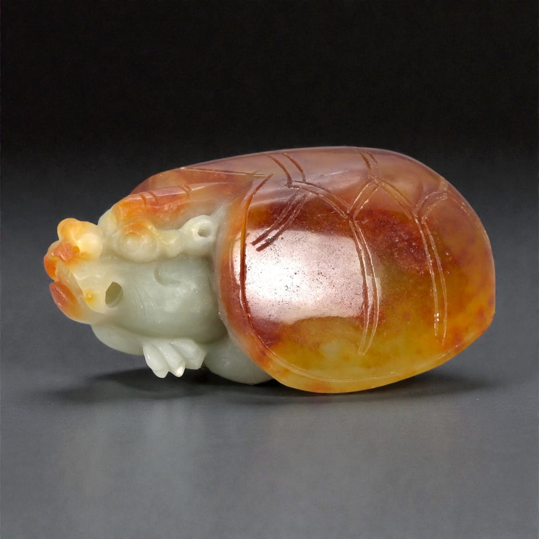 A Chinese Nephrite Jade Bixi Figure, 20th Century, 81FB: Carved from pale celadon nephrite jade with extensive russet and amber-colored skin retained from the original stone, the sculpture represents bixi, the mythical creature combining a tortoise body wit