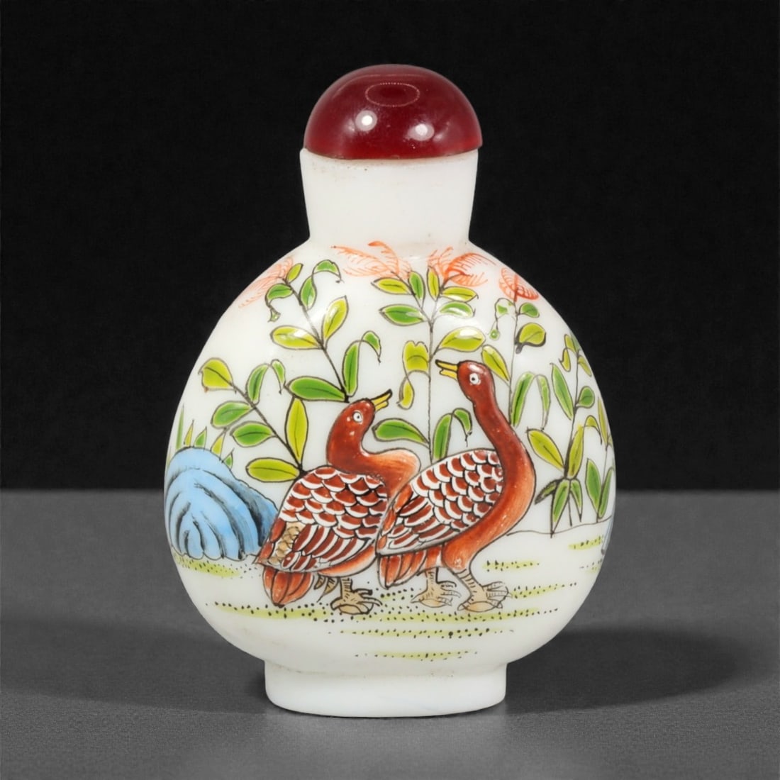 A Chinese Painted Glass Snuff Bottle, Guyuexuan Style, 20th Century, 14YC: Formed from opaque white glass, the bottle is of compressed globular form with rounded sides rising to a short cylindrical neck and flat foot. The exterior is painted in polychrome enamels with a figu