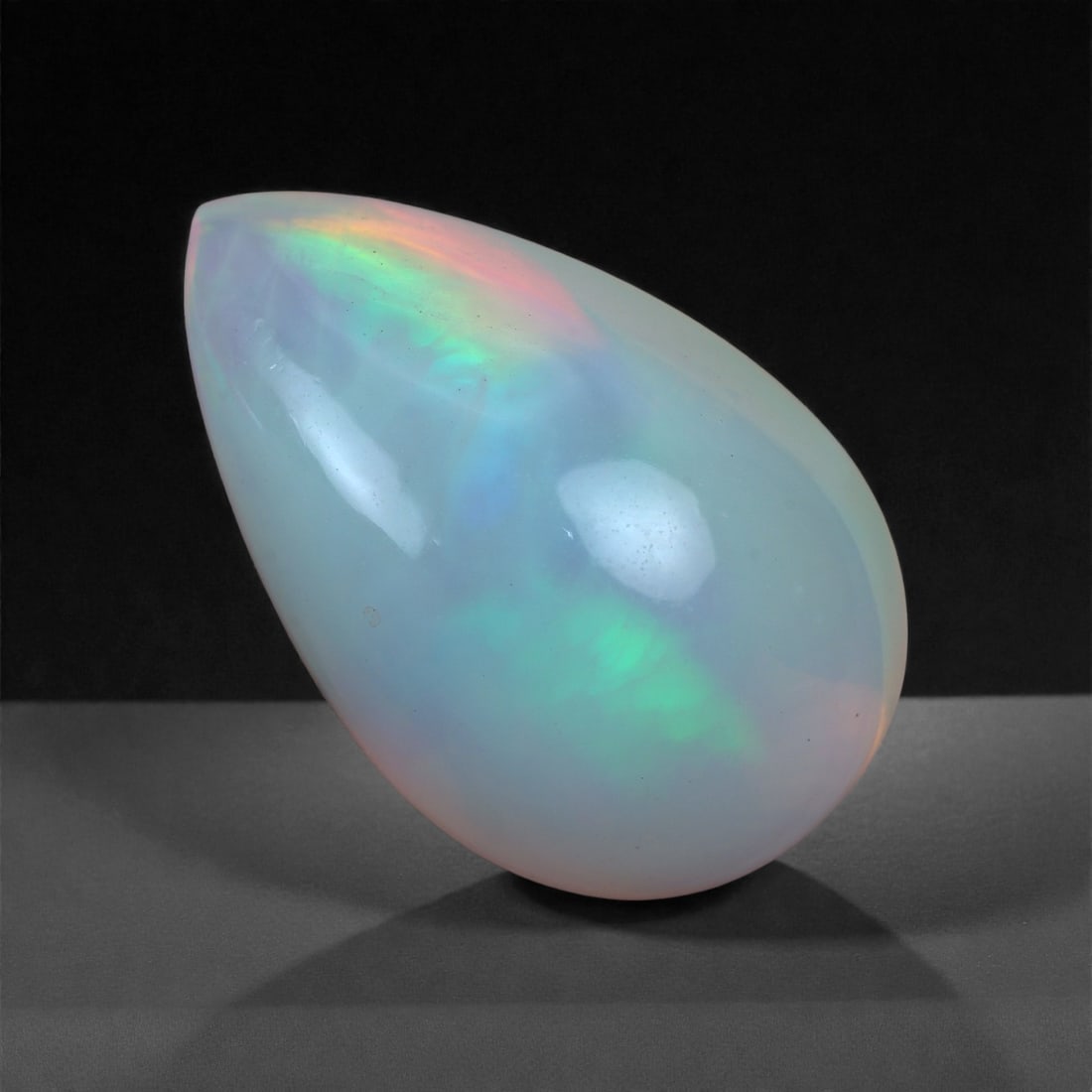 4.95 Carats Play-of-Color Welo Opal - Natural Ethiopian Gem 15x10mm, 35XA: This captivating Welo opal gleams with a luminous cascade of multi neon color that ripple across the stone's surface with every movement. The play-of-color is vivid and well-distributed, presenting a 