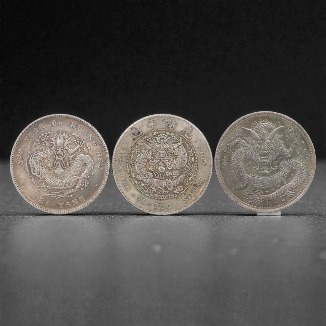 Three Chinese Commemorative Medallions Coins, 20th Century, 85FN: The group comprises three circular commemorative medallions, each with a diameter of 3.9 cm (1 1/2 in.). All three medallions feature a prominent five-clawed dragon motif in high relief at the center