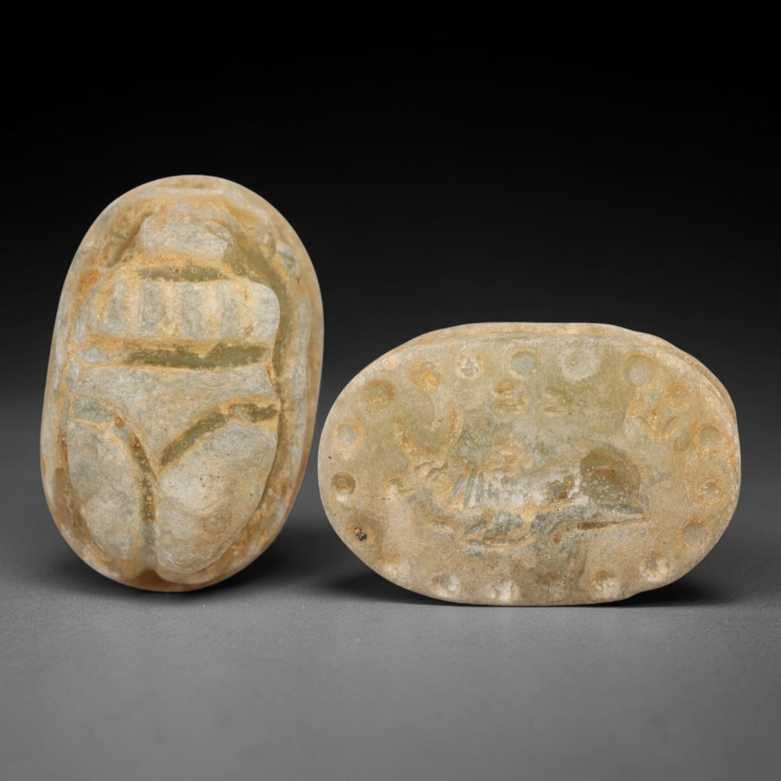 An Ancient Near Eastern Stone Scarab Stamp Seal, 1st Millennium BCE, 1AD: Carved from pale, translucent stone with natural surface encrustation and subtle tonal variation, the object is formed as an oval scarab seal. The dorsal side is modeled in low relief with a segmented
