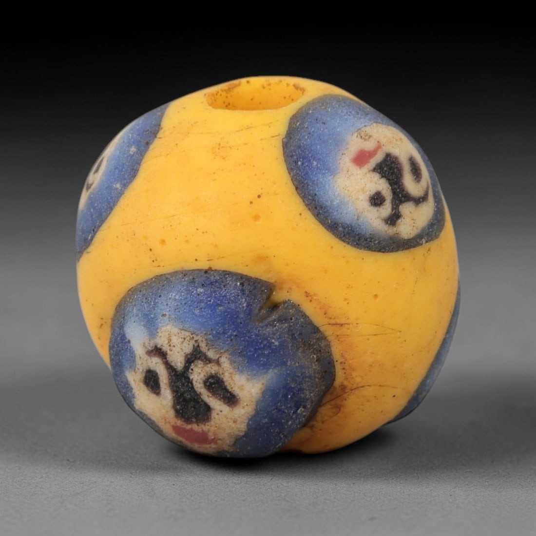 Medieval Face Bead - European Polychrome Glass Amulet Bead, 36ZM: This striking bead, measuring 1.8 cm (0.71 in), is a fine example of medieval European polychrome glass craftsmanship, executed using the trailed and inlaid techniques. Its spherical form is dominated