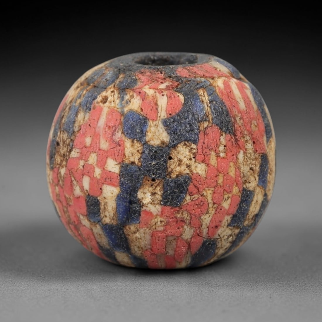Ancient Glass Mosaic Bead - Roman Bead, 49ZM: This ancient bead is crafted from polychrome mosaic glass, formed using the tesserae technique characteristic of Roman glassworking traditions. The spherical form features a dense pattern of red, blue