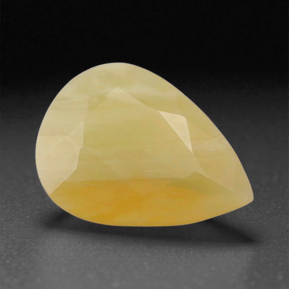 6.76 Carats Pale Yellow Mexican Fire Opal - Natural Stone - 17.9 x 13.6 x 6.9 mm, 25XK: This softly colored Mexican fire opal features a gentle yellow hue with creamy undertones and a subtle gradient of honey near the base. The stone's smooth, pear-shaped cut lends an organic elegance, w