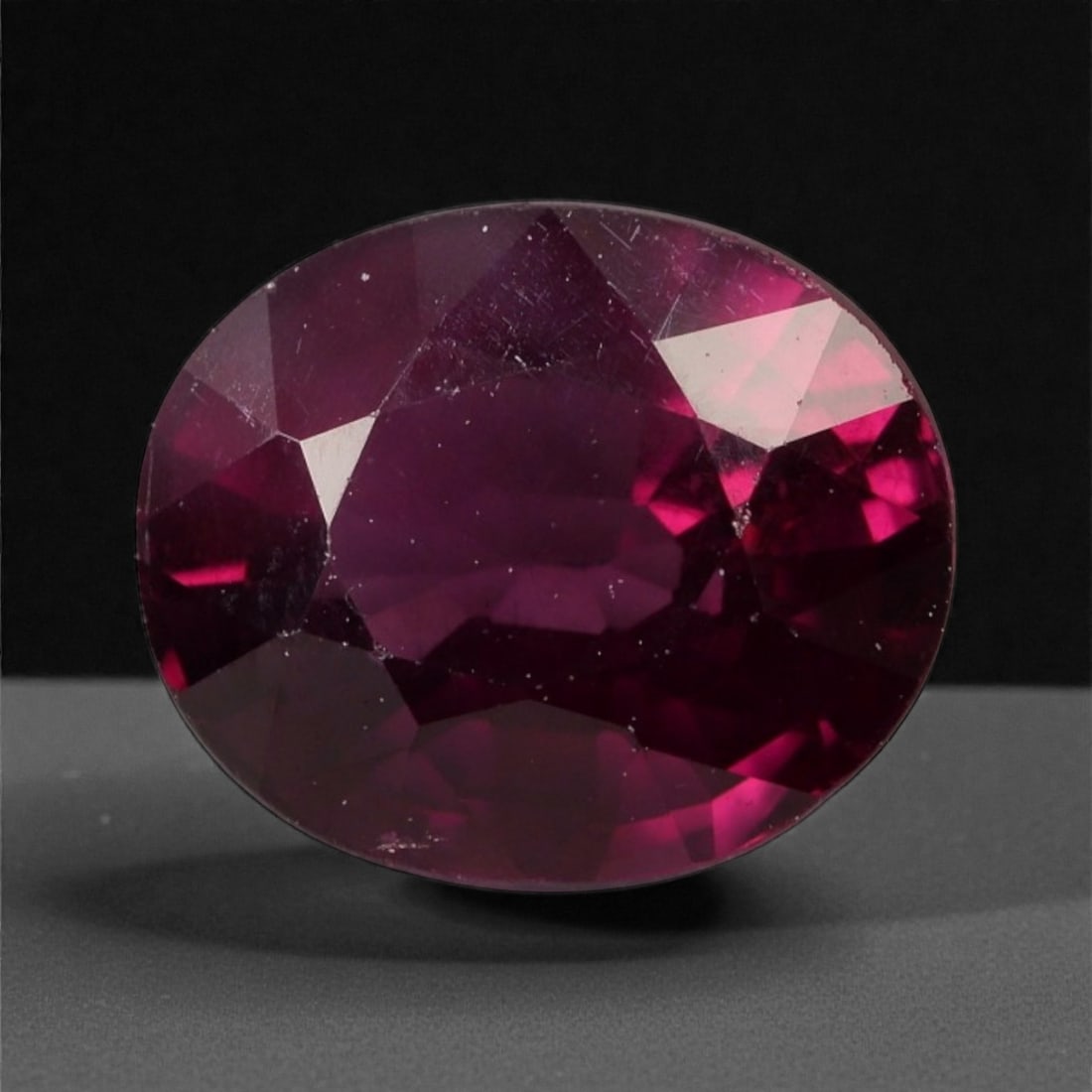 2.96 Carats Deep Red Garnet - Natural Mozambique - 8.6x7.1x5.2mm, 14WC: This bold oval-cut garnet glows with a velvety crimson tone, offering rich depth and an alluring play of burgundy and wine-red flashes. The gem's saturated body color and symmetrical faceting create a