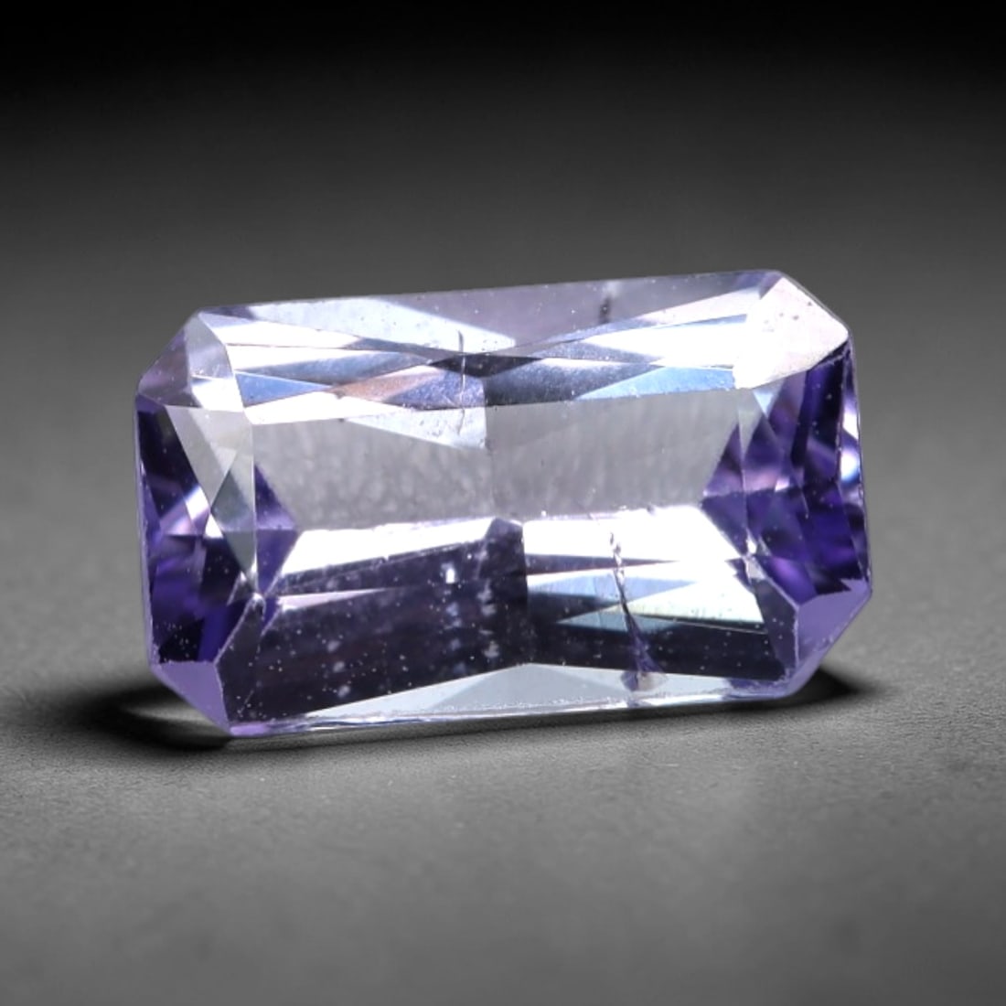 1.00 Carats Rectangular Mixed-Cut Tanzanite - Natural Tanzanian 7.7x4.6mm, 91XM: This rectangular mixed-cut tanzanite showcases a captivating, saturated violet-blue hue, with subtle undertones of deep purple and cool blue that create a multi-dimensional, velvety appearance. The ex