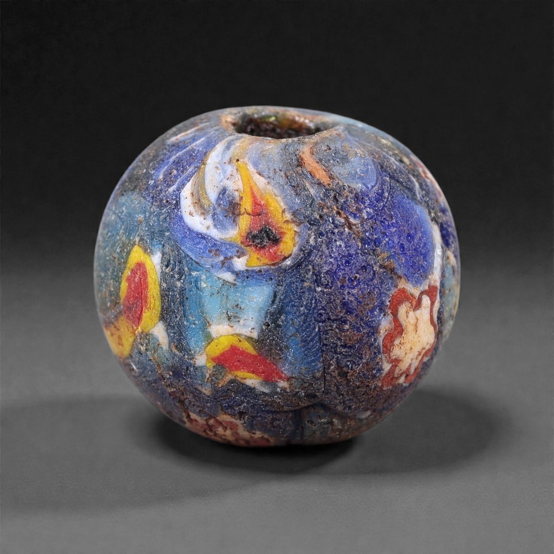Antique Glass Bead - Venetian Scramble Cane Sphere, 34Z: Formed of dense polychrome glass, this spherical bead was produced using the Venetian scramble cane technique, in which fragments of multicolored glass canes were irregularly assembled and fused befor