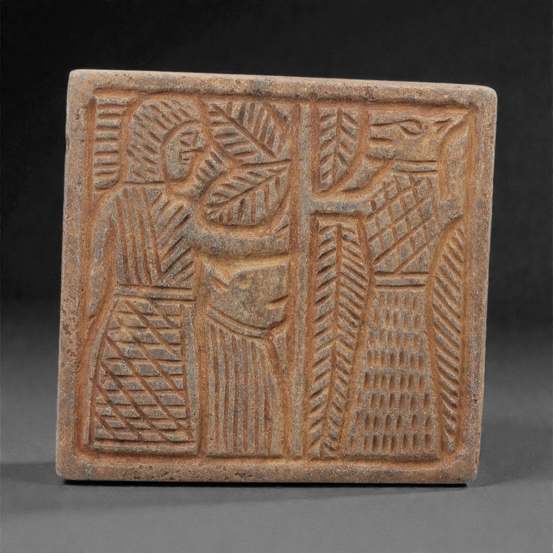 Ancient Near Eastern Lapis Lazuli Relief Plaque, 2nd-1st Millennium BCE, 85FM: A rectangular lapis lazuli relief plaque, measuring 7 x 6.5 cm, with a deep blue matrix and visible calcite inclusions, exhibiting natural surface patina and wear. The plaque is divided into two regis