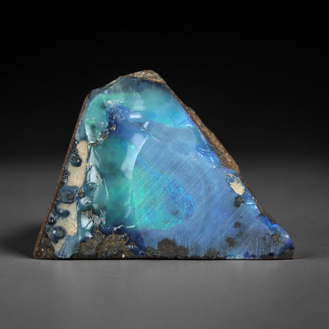 9.87 Carats Iridescent Blue-Green Winton Opal Rough - Natural Australian Specimen 18x15mm, 81XM: This exceptional rough opal from Winton, Australia, captivates with a vivid play of color, where intense flashes of celestial blue and vibrant green swirl through a milky, translucent base. The natura