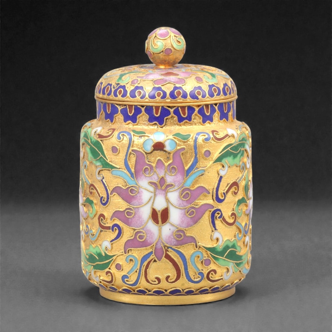 A Chinese Cloisonne Enamel Covered Box, 20th Century, 47FK: The covered box is of cylindrical form with straight sides and a fitted domed lid surmounted by a spherical knop, constructed in copper and decorated using the cloisonne enamel technique. The exterior