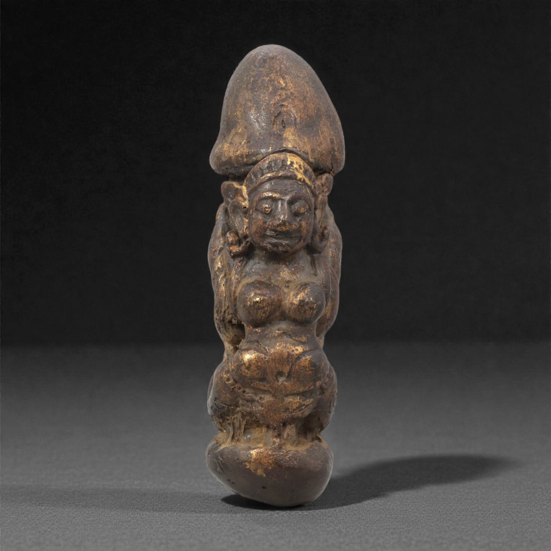 An Indo-Himalayan Phallic Amulet, 20th Century, 25ZG: The amulet is formed as a vertical composite phallic shape incorporating a standing female figure carved in relief. The figure is presented frontally with rounded facial features, shallowly defined ey