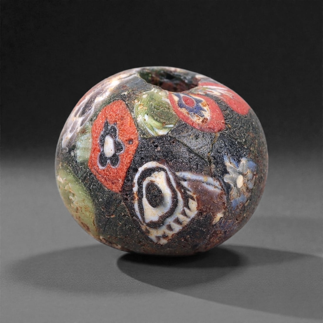 Antique Glass Bead - Venetian Scramble Cane Sphere, 58Z: Formed of dense polychrome glass, this spherical bead was produced using the Venetian scramble cane technique, in which fragments of multicolored glass canes were irregularly assembled and fused into
