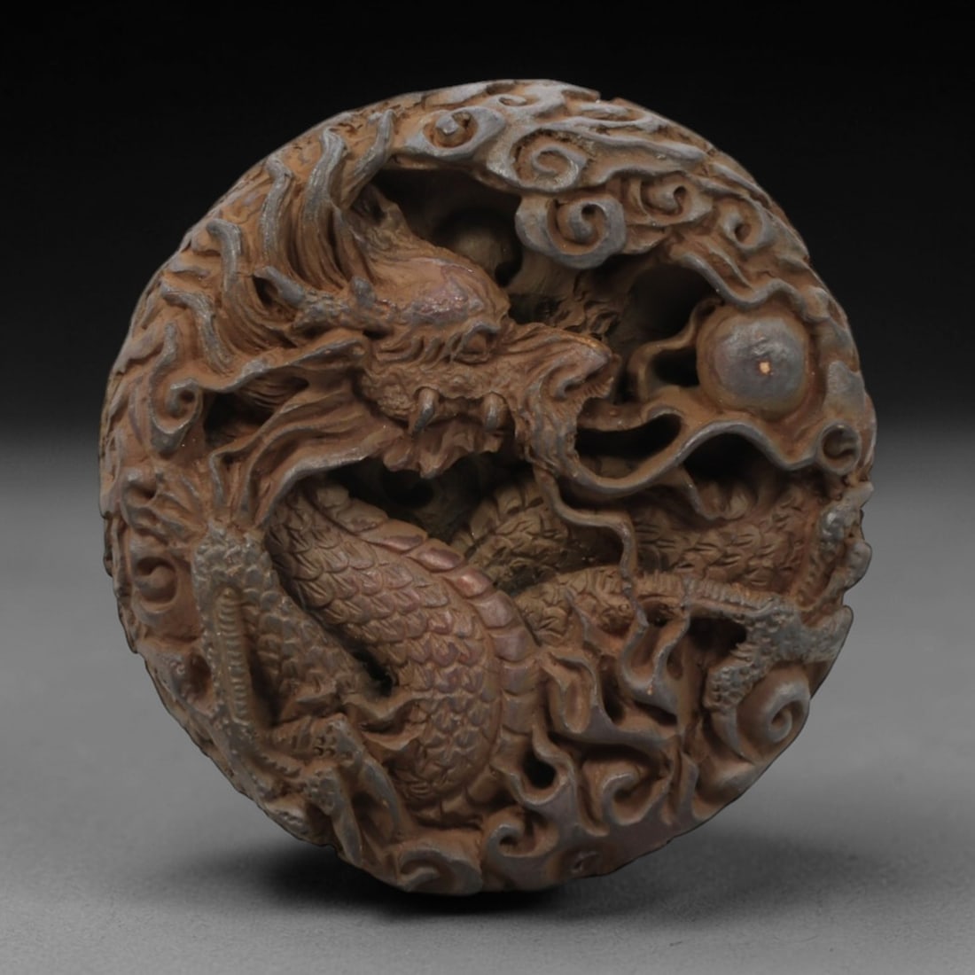 A Chinese Horn or Bone Dragon and Phoenix Pendant Amulet, 20th Century, 83FV: Carved from horn or bone with a naturally aged, patinated surface and subtle tonal variations, the pendant is circular in form, with one side depicting a dragon and the reverse a phoenix. The dragon i