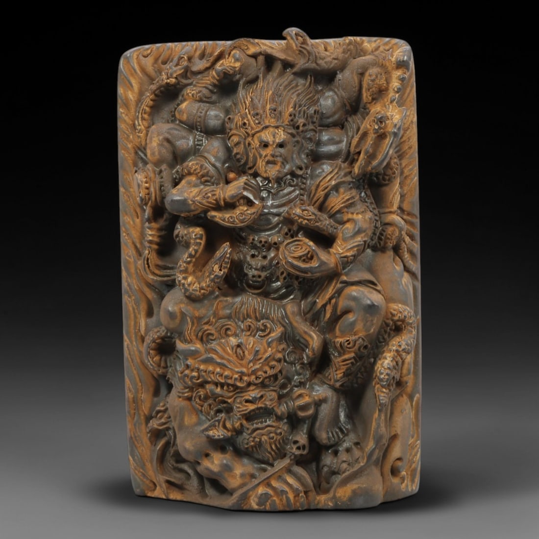 A Chinese Horn or Bone Yama and Beast Plaque, 20th Century, 94FV: Carved from horn or bone with a naturally aged, patinated surface and subtle tonal variations, the plaque is rectangular in form, depicting Yama seated atop a fierce beast. Yama is rendered in high re