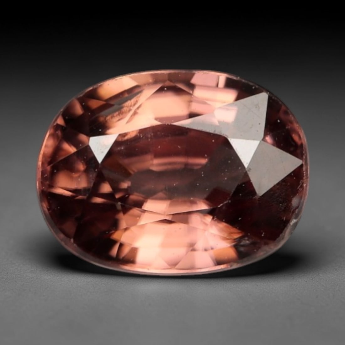 1.142 Carats Orange Purplish Zircon - Natural Loose Gemstone, LZ271: This singular oval mixed-cut zircon captivates with a rich, warm orange base infused with subtle purplish undertones, creating a rare and alluring color profile that shifts beautifully under light. Th
