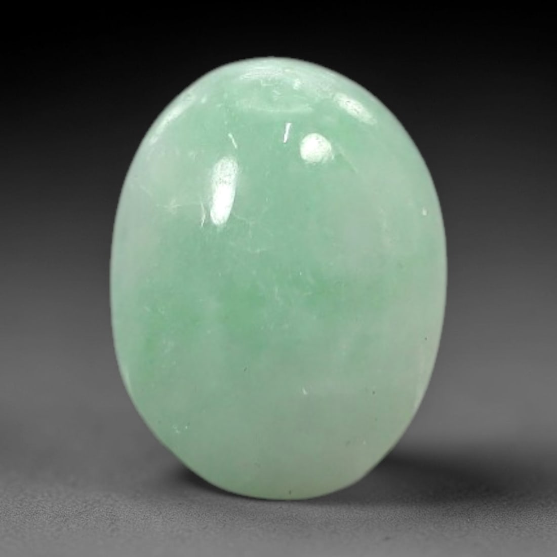 3.92 Carats Apple Green Burmese Jadeite Jade Cabochon - Natural Loose Gemstone, 84XN: This singular Burmese jadeite jade cabochon presents a luminous apple green hue, soft and luminous with a translucent quality that allows light to filter gently through its smooth, domed surface. The