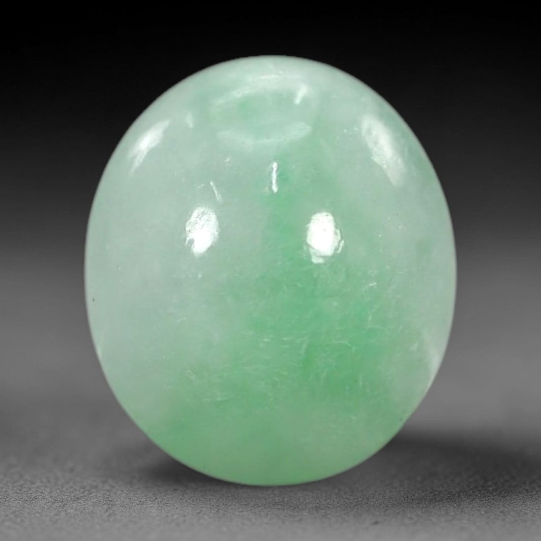 3.14 Carats Apple Green Burmese Jadeite Jade Cabochon - Natural Loose Gemstone, 54XN: This singular Burmese jadeite jade cabochon presents a luminous apple green hue, soft and luminous with a translucent quality that allows light to filter gently through its smooth, domed surface. The