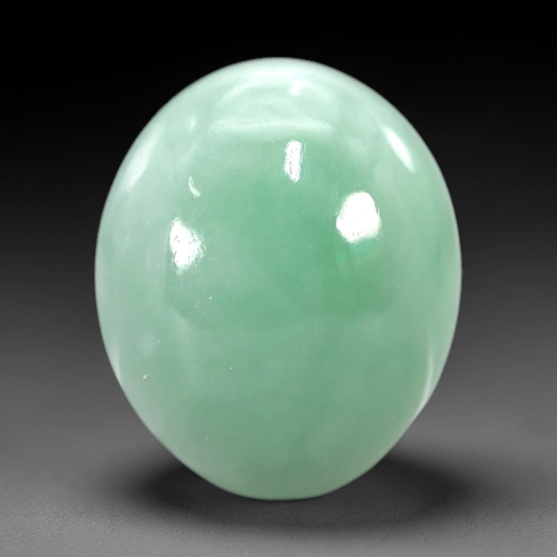 5.70 Carats Pale Green Translucent Jadeite Jade Cabochon - Natural Burmese Stone, 42AB: This jadeite jade cabochon is fashioned into a classic oval form with a highly polished, domed surface that exhibits a consistent pale green hue throughout its translucent body. The material displays