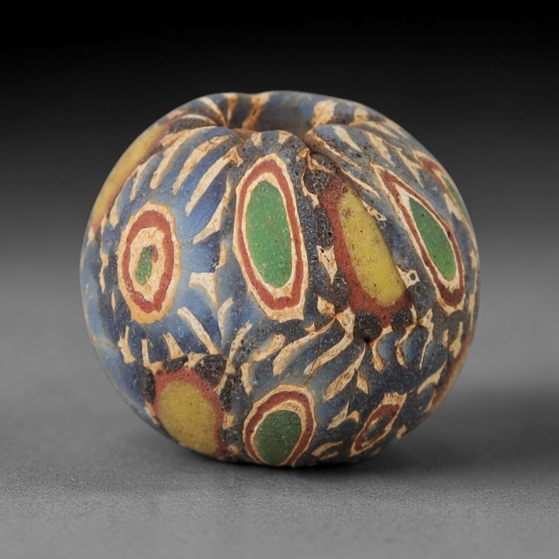 Ancient Glass Eye Bead - Egyptian Amulet Bead, 54ZM: This ancient bead is crafted from polychrome glass, formed using core-formed and trailed decorative techniques characteristic of Egyptian glassworking traditions. The spherical form features multiple