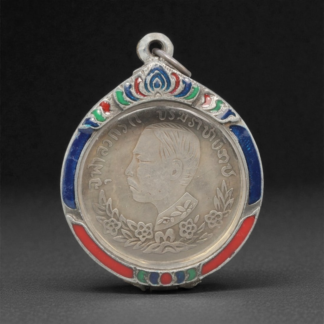A Thai King on Elephant Commemorative Medal Pendant, 20th Century, 98FN: This circular pendant features a silver commemorative medal, encased in an ornate silver frame with a transparent protective cover, measuring 4.5 x 5.9 cm (1 3/4 x 2 5/16 in.). The obverse of the meda