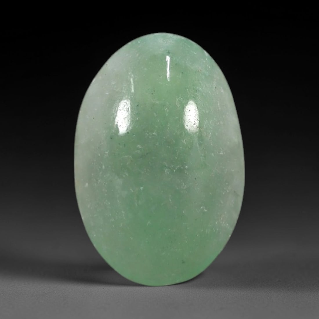 3.10 Carats Apple Green Burmese Jadeite Jade Cabochon - Natural Loose Gemstone, 62XN: This singular Burmese jadeite jade cabochon presents a luminous apple green hue, soft and luminous with a translucent quality that allows light to filter gently through its smooth, domed surface. The